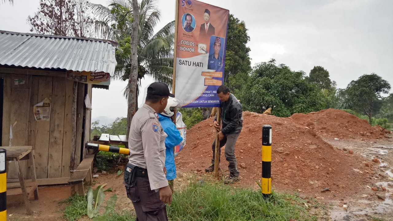 Masa Tenang Pemilu 2019, Bhabinkamtibmas Bantu Bersihkan Alat Peraga Kampanye Disepanjang Jalan Trans Flores