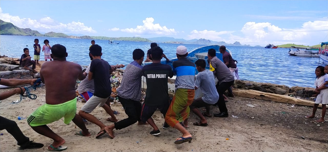 Bentuk Perhatian Polri Kepada Nelayan, Bhabinkamtibmas Desa Komodo Bantu Mengangkat Perahu ke Daratan